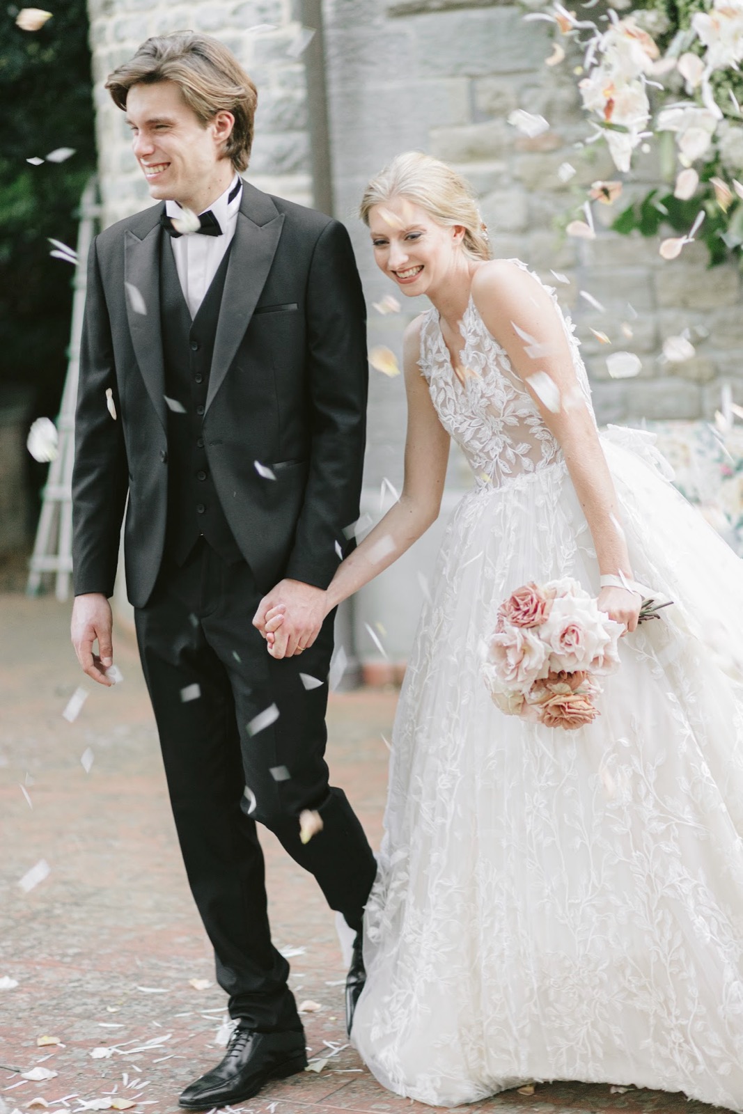 Bride and groom laughing together in a shower of confetti after their Italian wedding ceremony